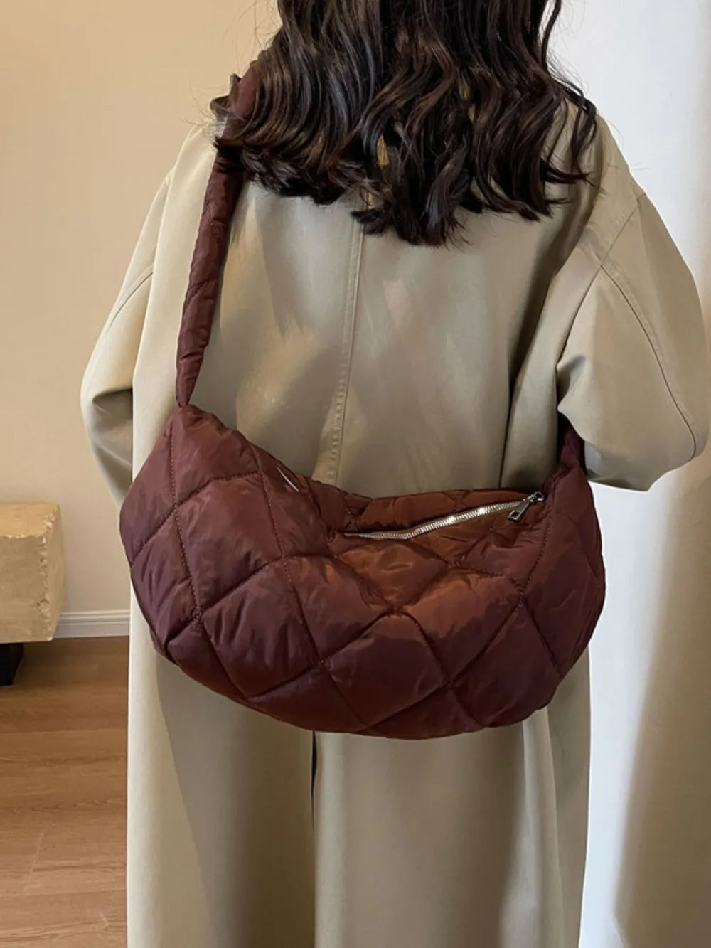 Quilted crossbody bag in brown with a diamond pattern and silver zipper detail.
