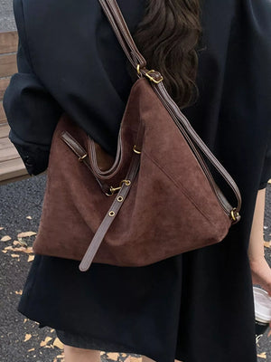 Brown suede tote bag with leather strap details and gold hardware.