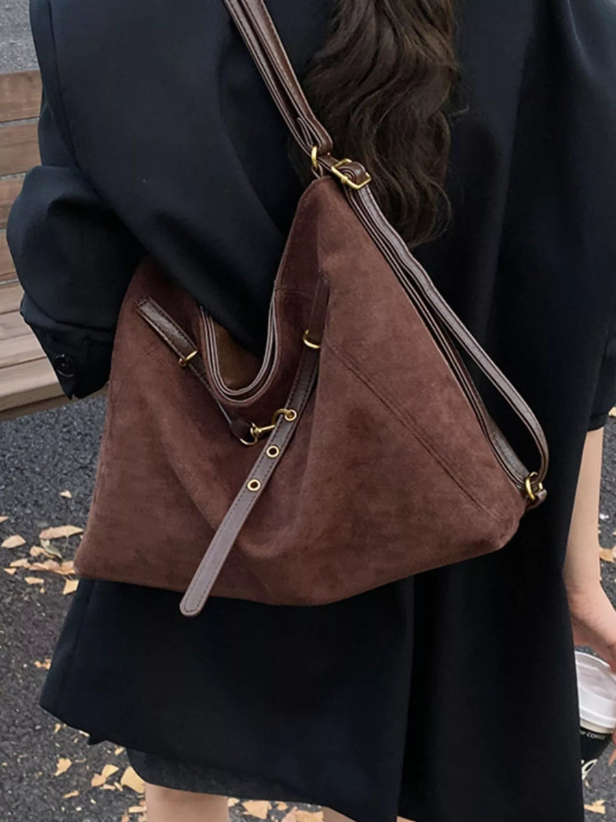 Brown suede tote bag with leather strap details and gold hardware.