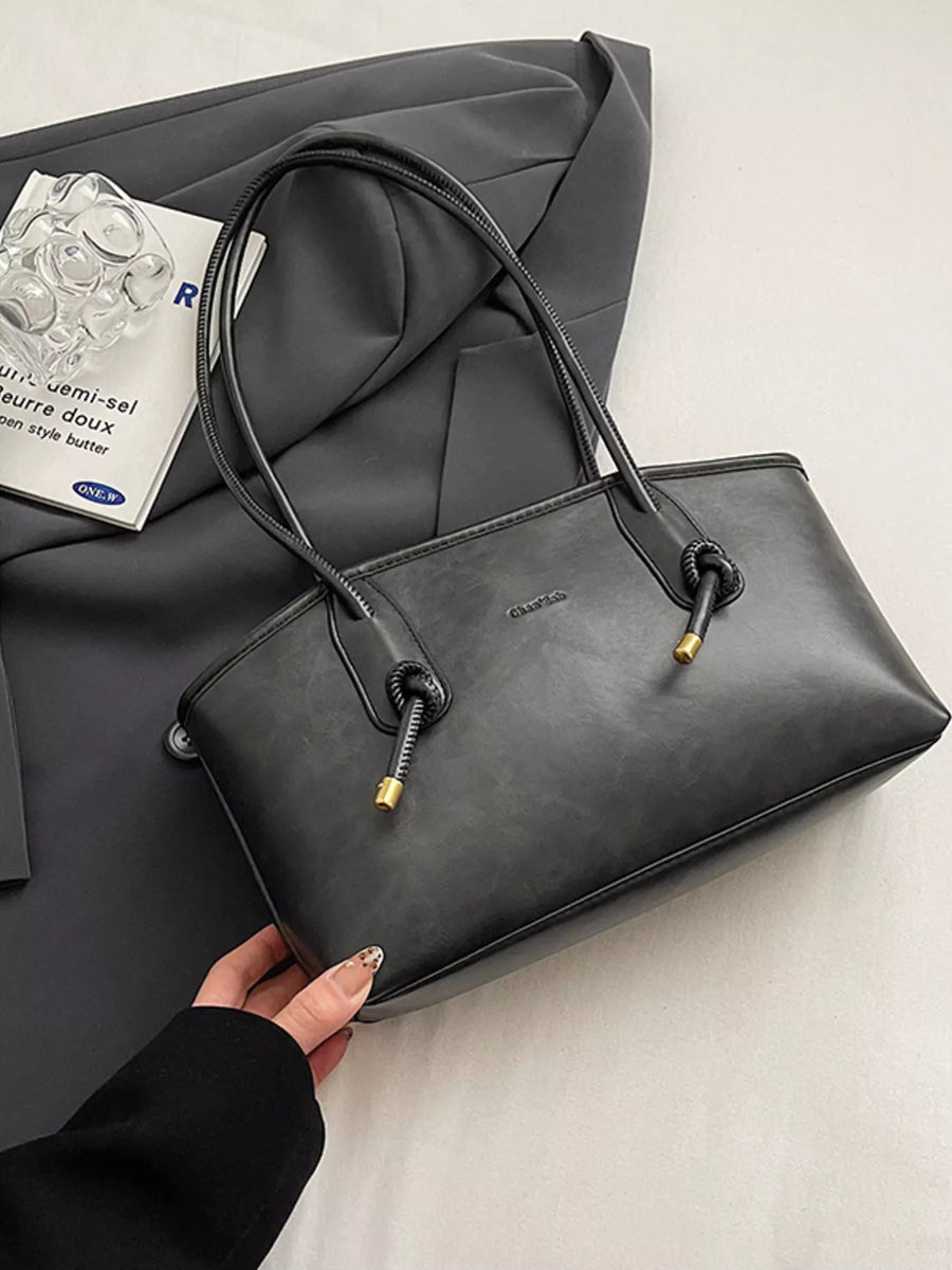 Black leather shoulder bag with knotted strap details and gold hardware.