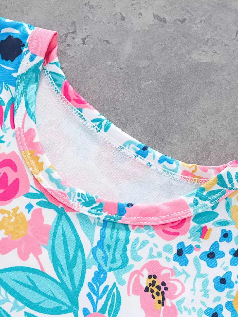 T-shirt with a vibrant floral print, round neckline, and pink trim.