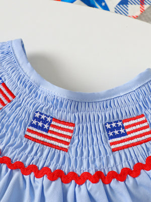Baby smocked top with embroidered American flags and red ric rac trim.