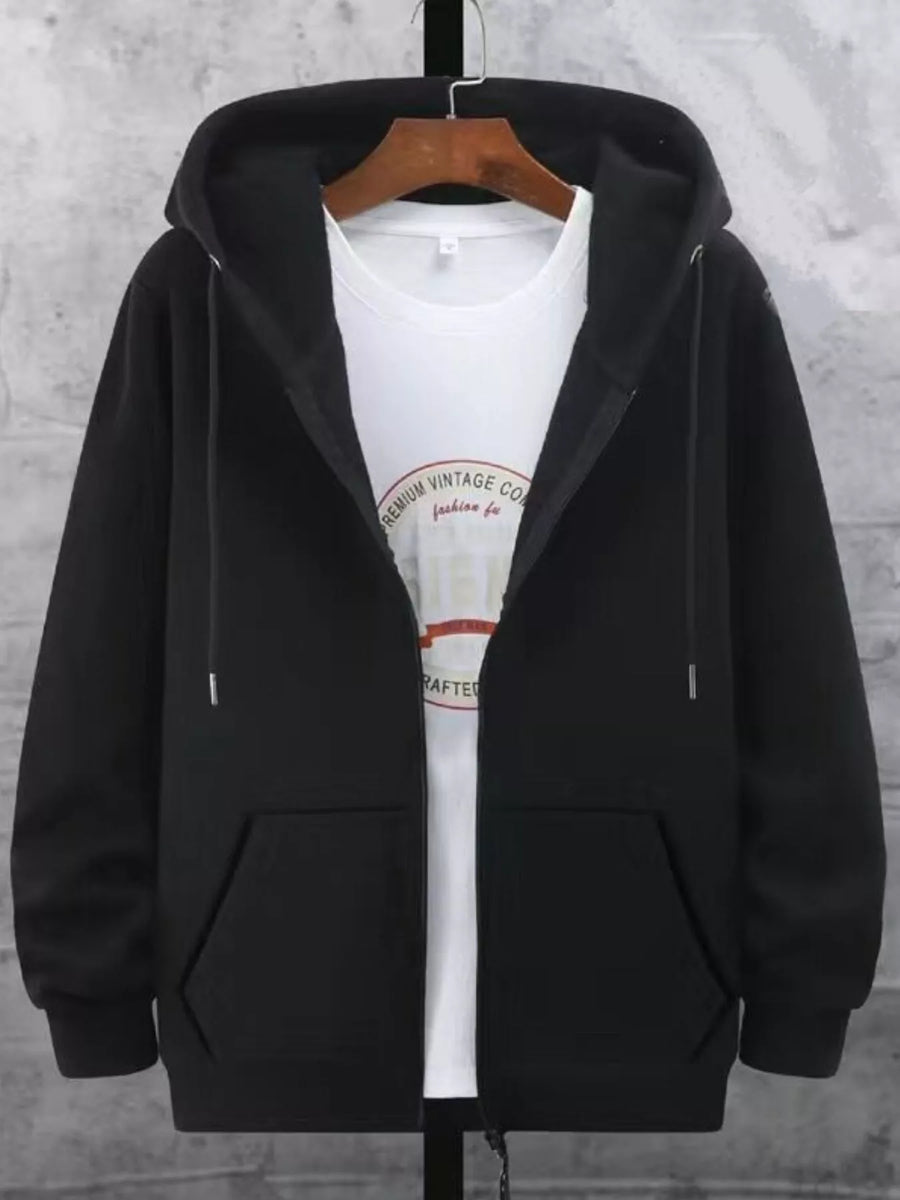 Black fleece-lined zip-up hoodie with front pockets and drawstring hood, worn over a white graphic tee.