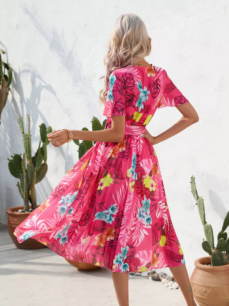Hot pink tropical pleated midi dress with belt and short sleeves.