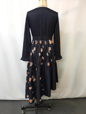 Elegant black long sleeve maxi dress with floral print skirt and ruffled cuffs.