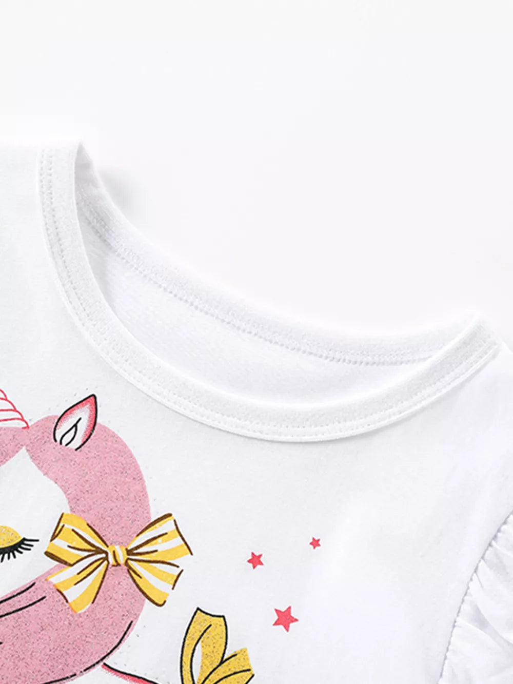 White cotton baby dress with pink unicorn print, yellow bow, and ruffled sleeves.