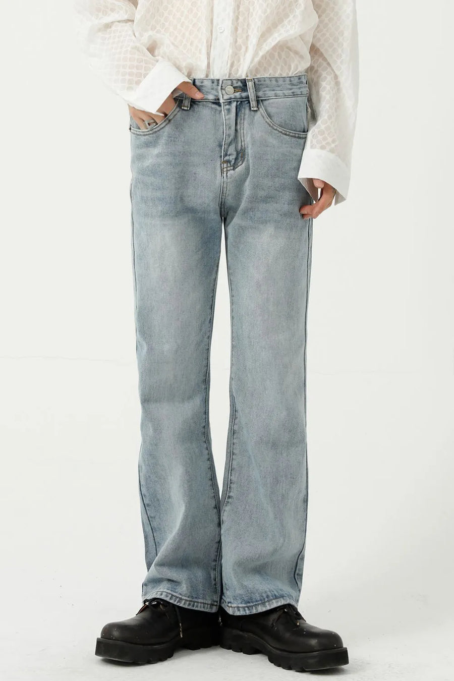 Relaxed flare denim trousers in light blue, with a subtle fade and wide leg opening.