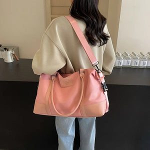 Blush pink duffel bag with two handles and a detachable shoulder strap, two-tone design