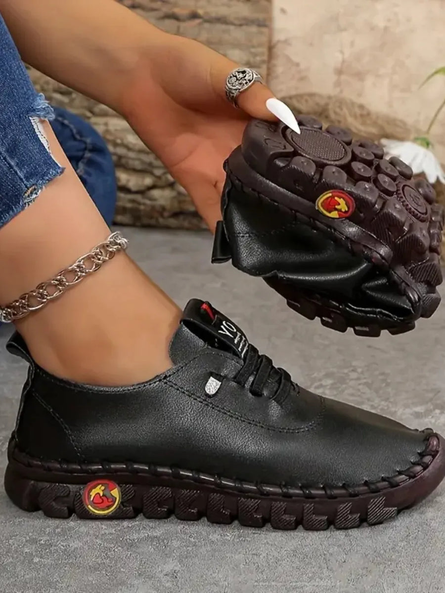 Black faux leather loafers with stitched sole and lug sole detail.