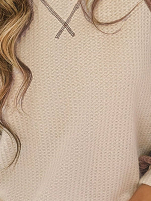 Beige waffle knit raglan sleeve sweater with contrast stitching detail at the neckline.