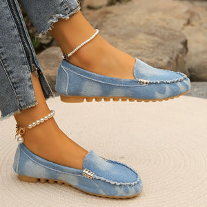 Light denim loafers with contrast stitching and metal detail.