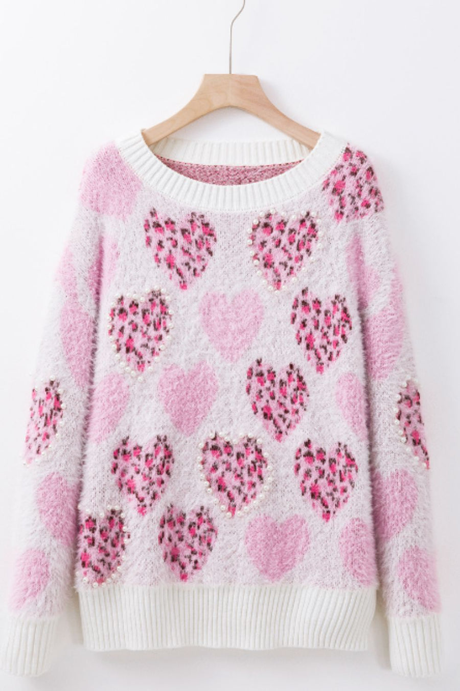 Fuzzy knit sweater in blush pink with allover heart pattern and pearl embellishments.