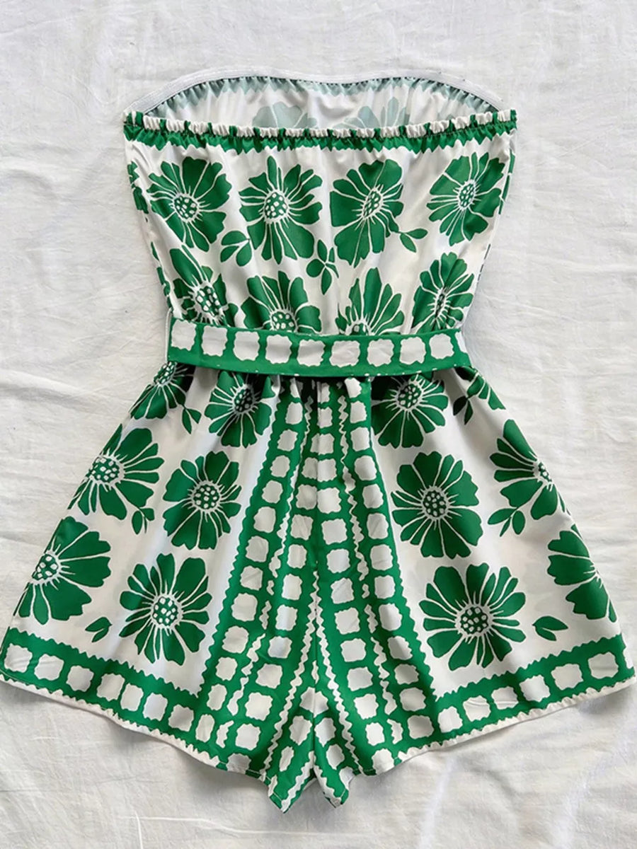 Green floral tie-waist strapless romper with a ruffled hem and playful geometric print.