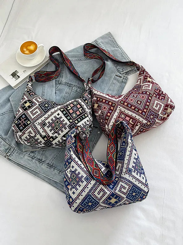 Embroidered geometric hobo bags in blue, red, and black with patterned straps.