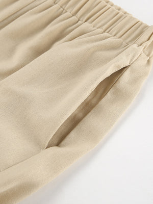 Tan cotton wide-leg pants with elastic waistband and pocket detail.