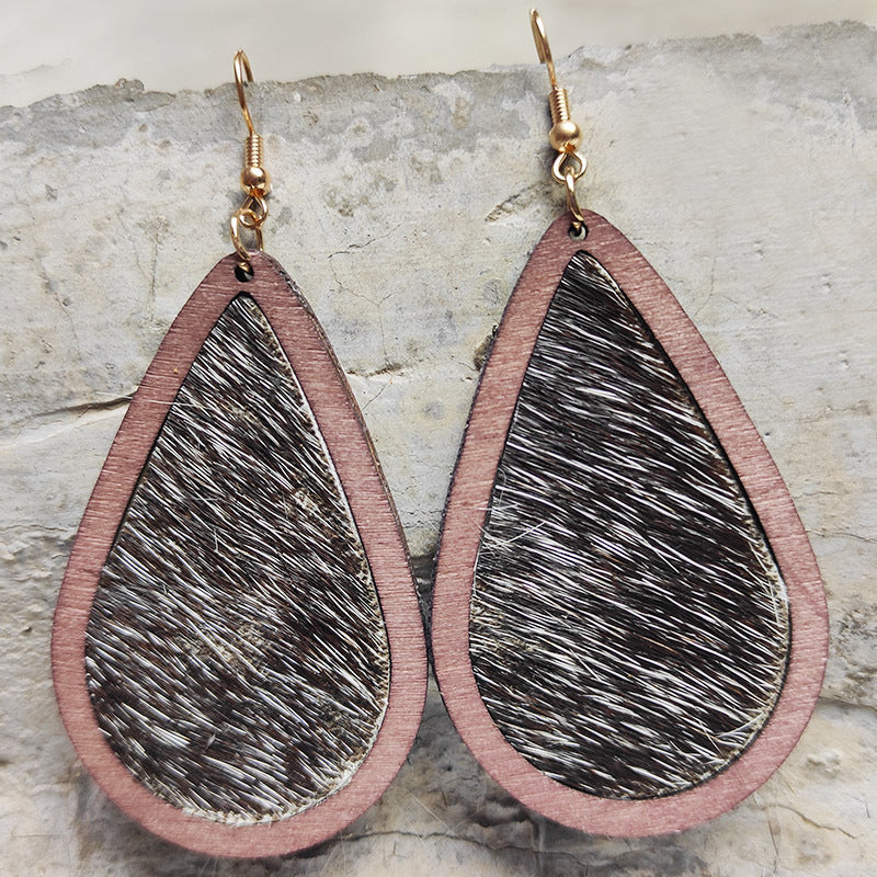 Teardrop wood earrings with leopard print texture and rose gold hooks.