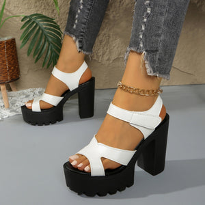 White open-toe sandals with black platform and block heel, featuring white straps and a chunky sole.