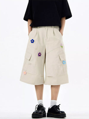 Tan cotton cargo shorts with floral appliques and wide legs.