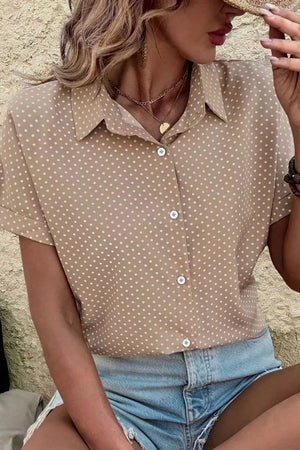 Chic polka dot button-up blouse with cuffed short sleeves and a collared neckline.