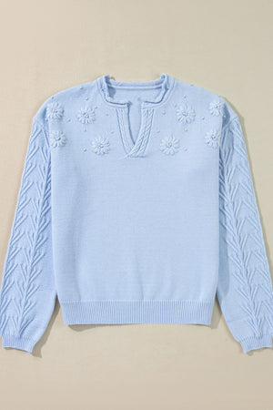 Light blue sweater with floral applique and cable knit sleeves