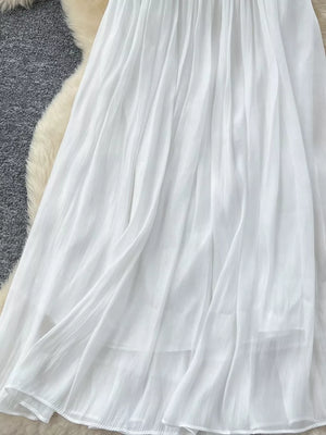 White pleated maxi skirt with flowing fabric and delicate pleats.