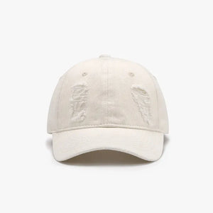 Ivory distressed denim baseball cap with ripped details.