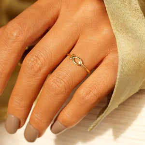 Gold ring with delicate fish motif and zircon detail.