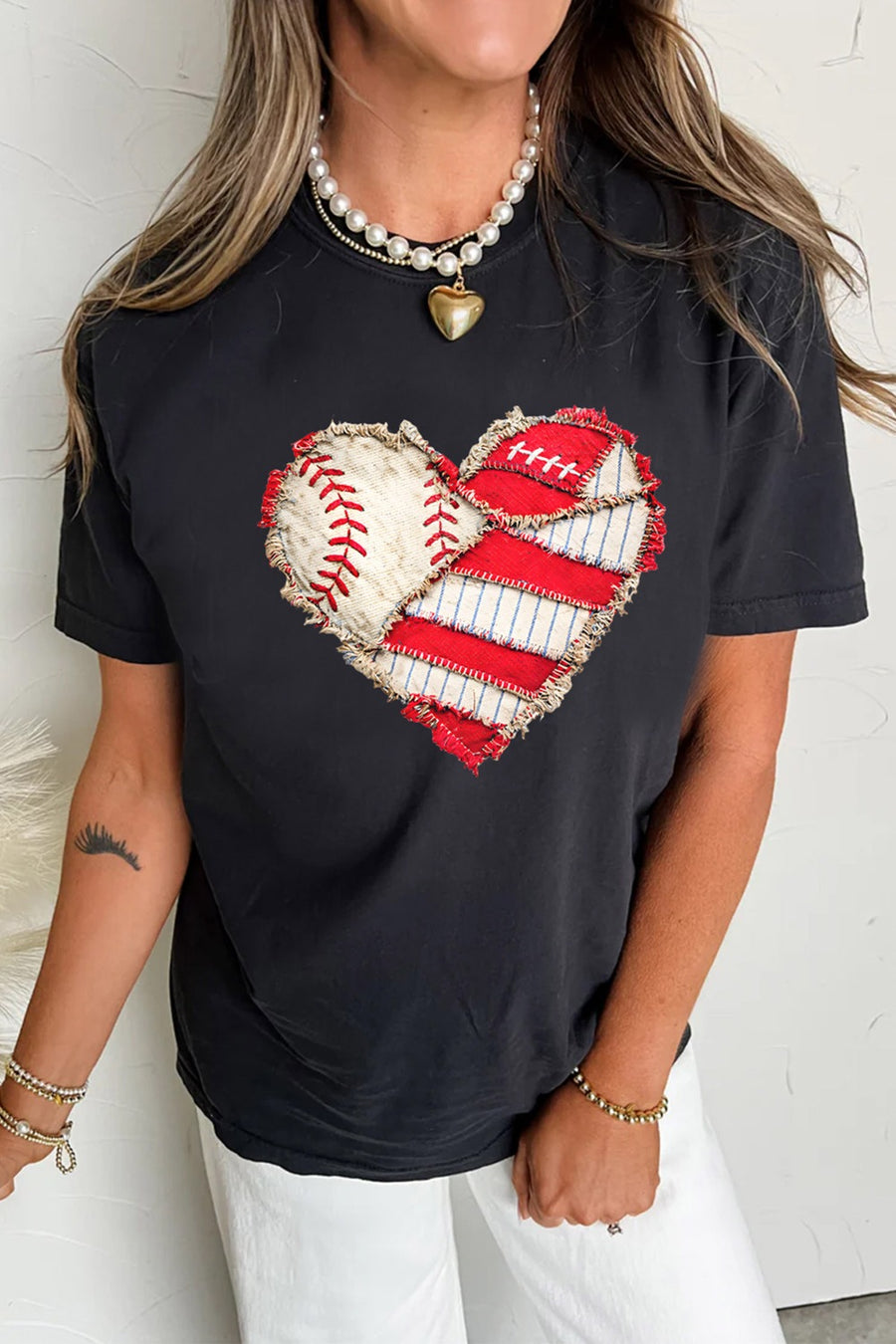 Black cotton t-shirt with distressed baseball and stripe heart graphic.