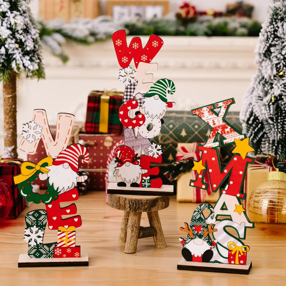 Wooden gnome holiday word blocks spelling "WELCOME" and "XMAS" with festive patterns and snowflakes.