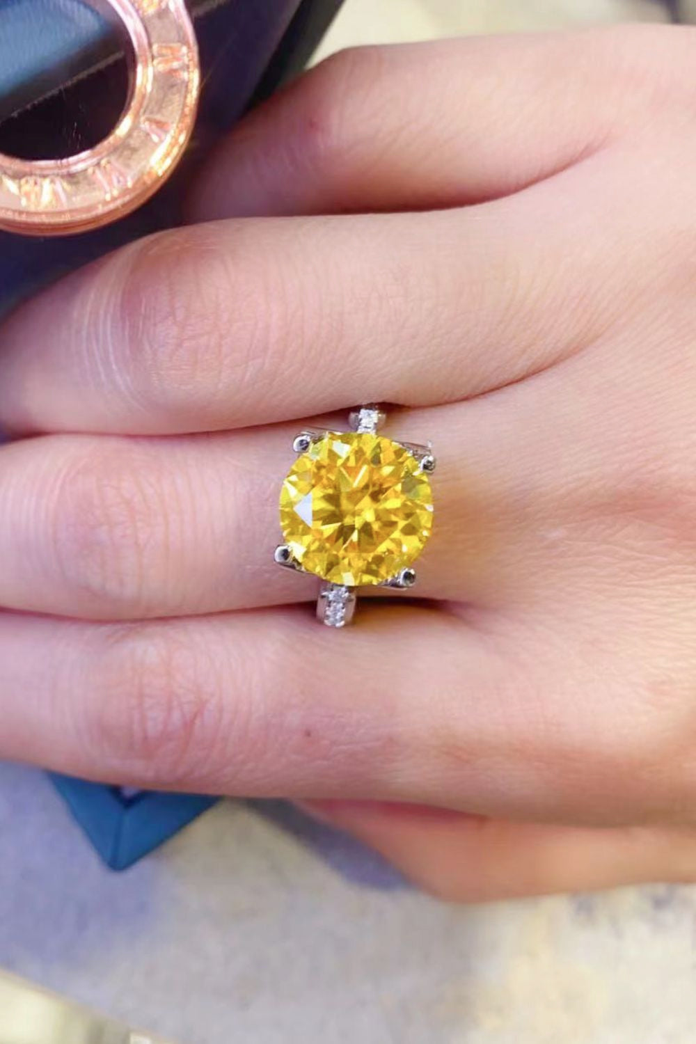 Silver solitaire ring with a bright yellow canary diamond and accent stones.