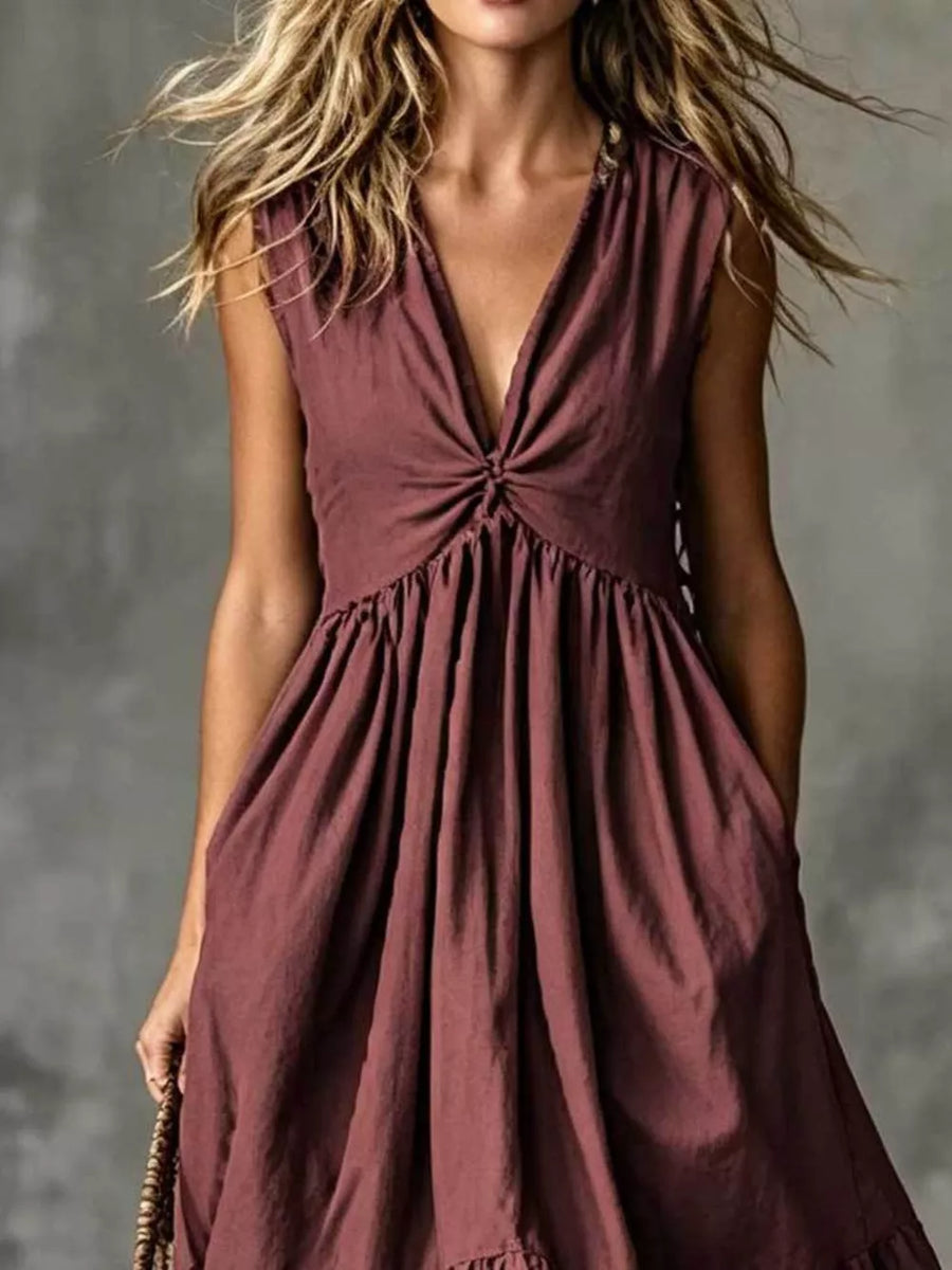 Sleeveless plum linen blend dress with deep V-neck and knotted bust detail, gathered waist and pockets.