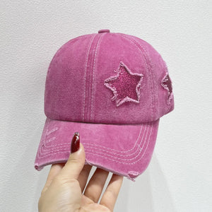 Stellar snapback cap in hot pink with glitter star patches and distressed details.