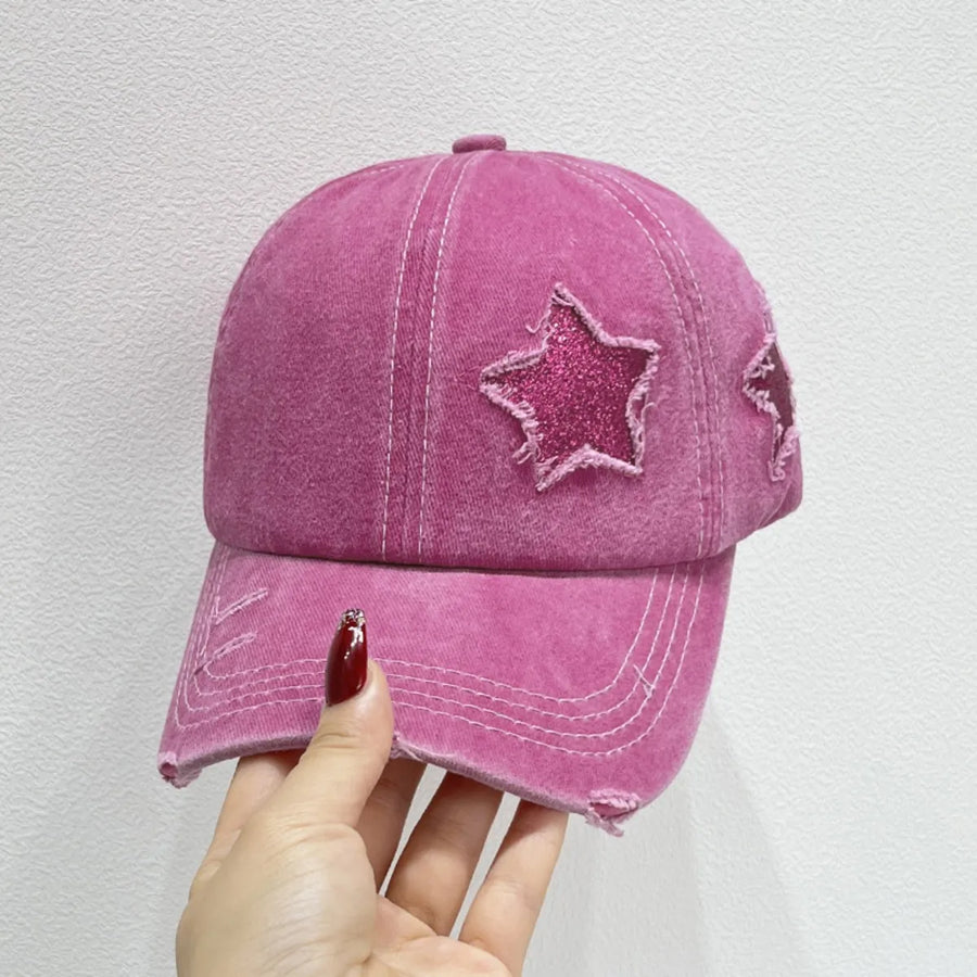Stellar snapback cap in hot pink with glitter star patches and distressed details.