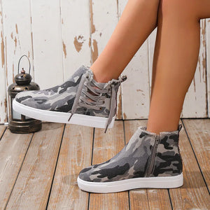 Green camouflage canvas zip-up sneaker booties with lace-up detail and frayed edges.