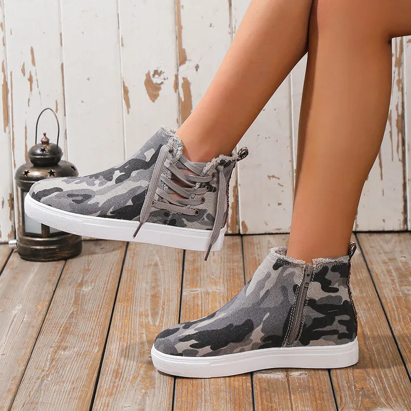 Green camouflage canvas zip-up sneaker booties with lace-up detail and frayed edges.