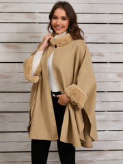 Tan faux fur trimmed cape coat with open front and wide sleeves.