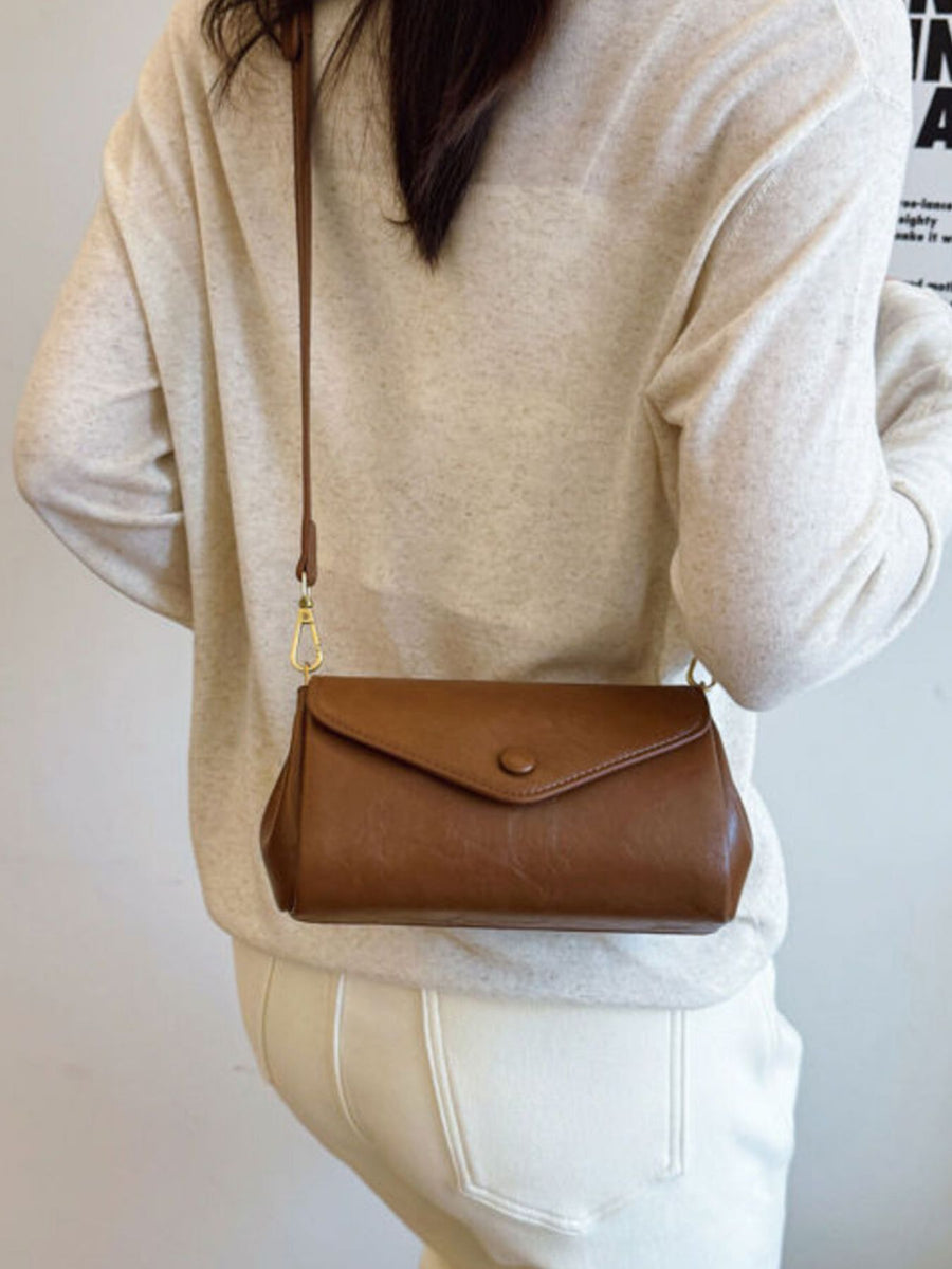 Mini pu leather flap crossbody bag in light brown with a button closure.