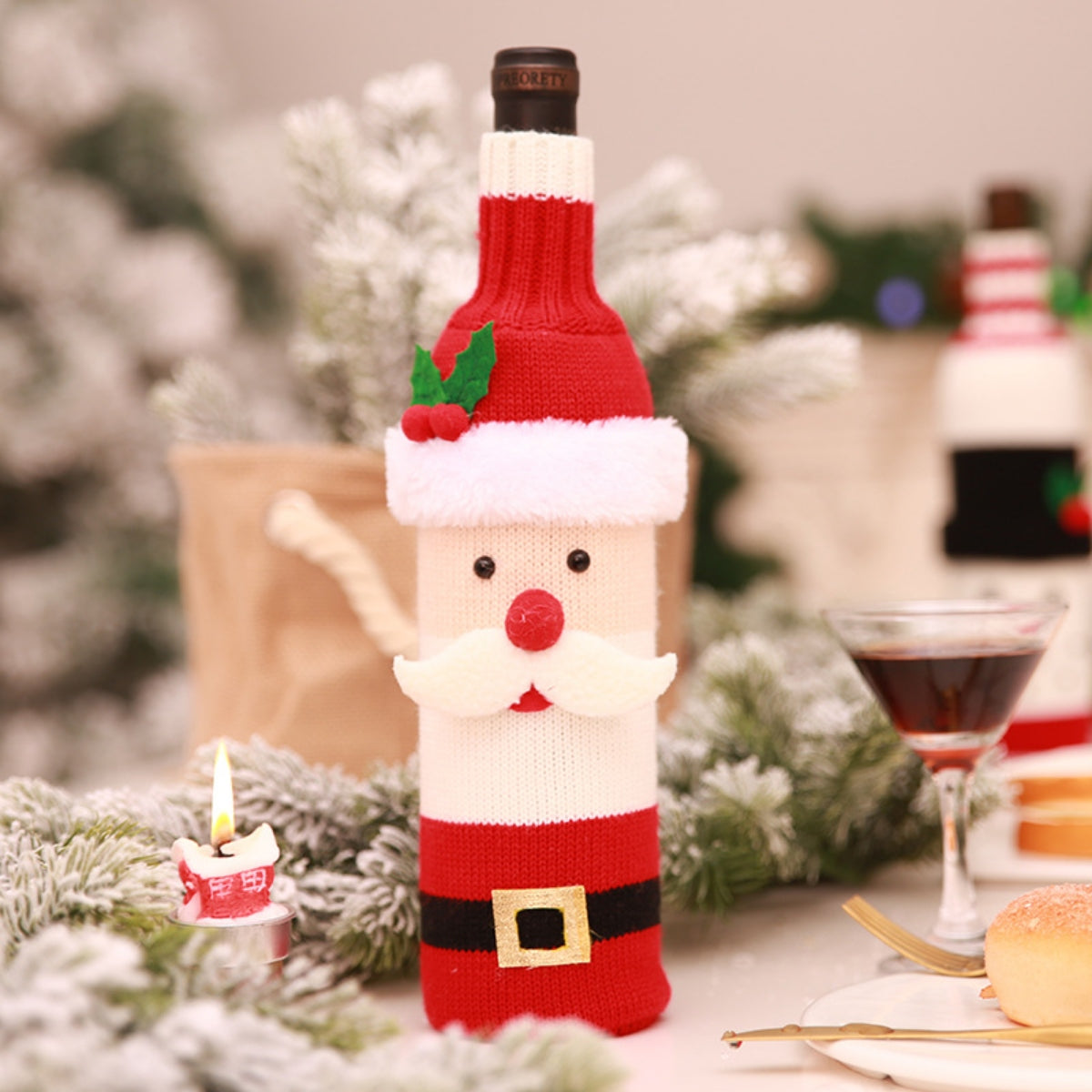 Festive knit bottle cover in Santa Claus design, red and white with black belt detail.
