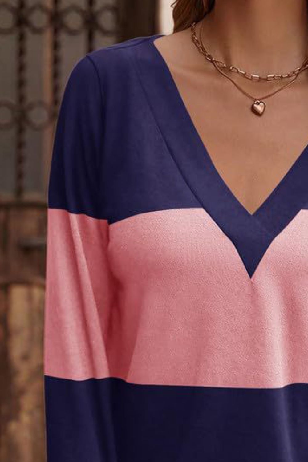 Colorblock V-neck knit top with pink and navy blue panels.