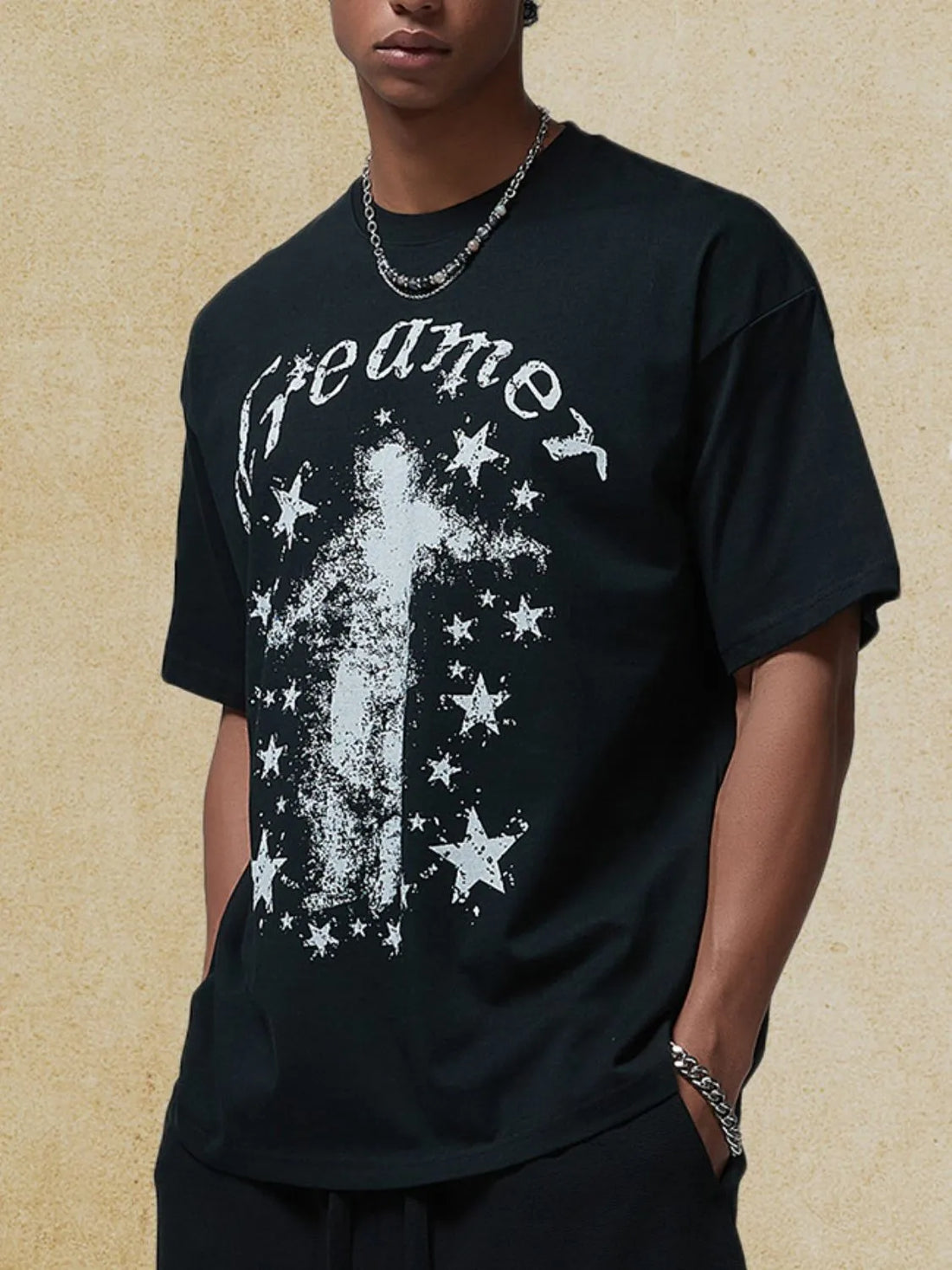 Black graphic t-shirt with white distressed "dreamer" text and star pattern.
