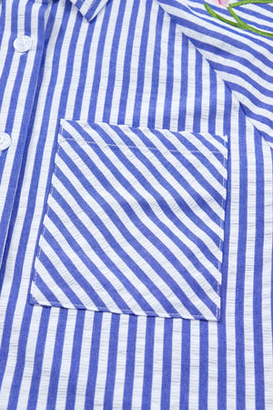 Blue and white striped button-down shirt with a pocket and floral embroidery detail.