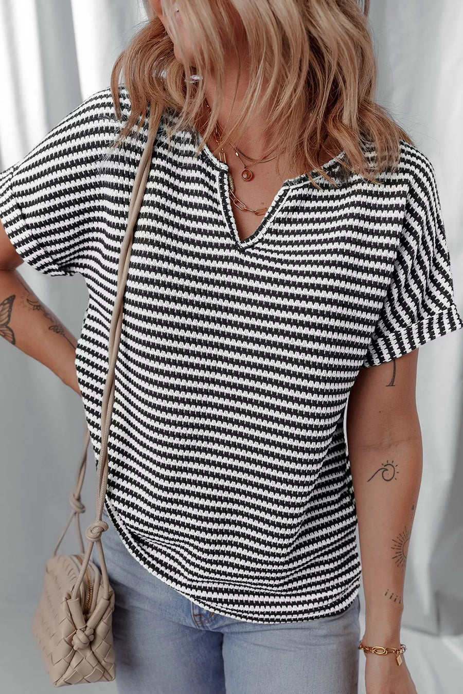 Textured knit t-shirt with black and white stripes and a notched neckline.
