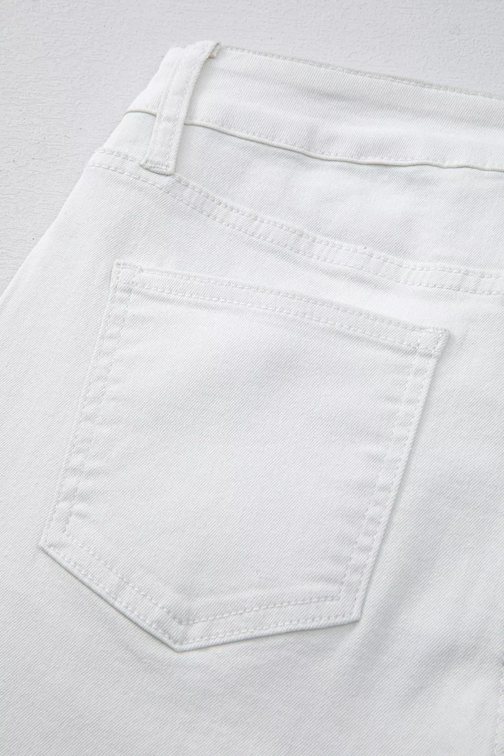 White denim jeans with high waist and straight leg cut, showing back pocket detail.
