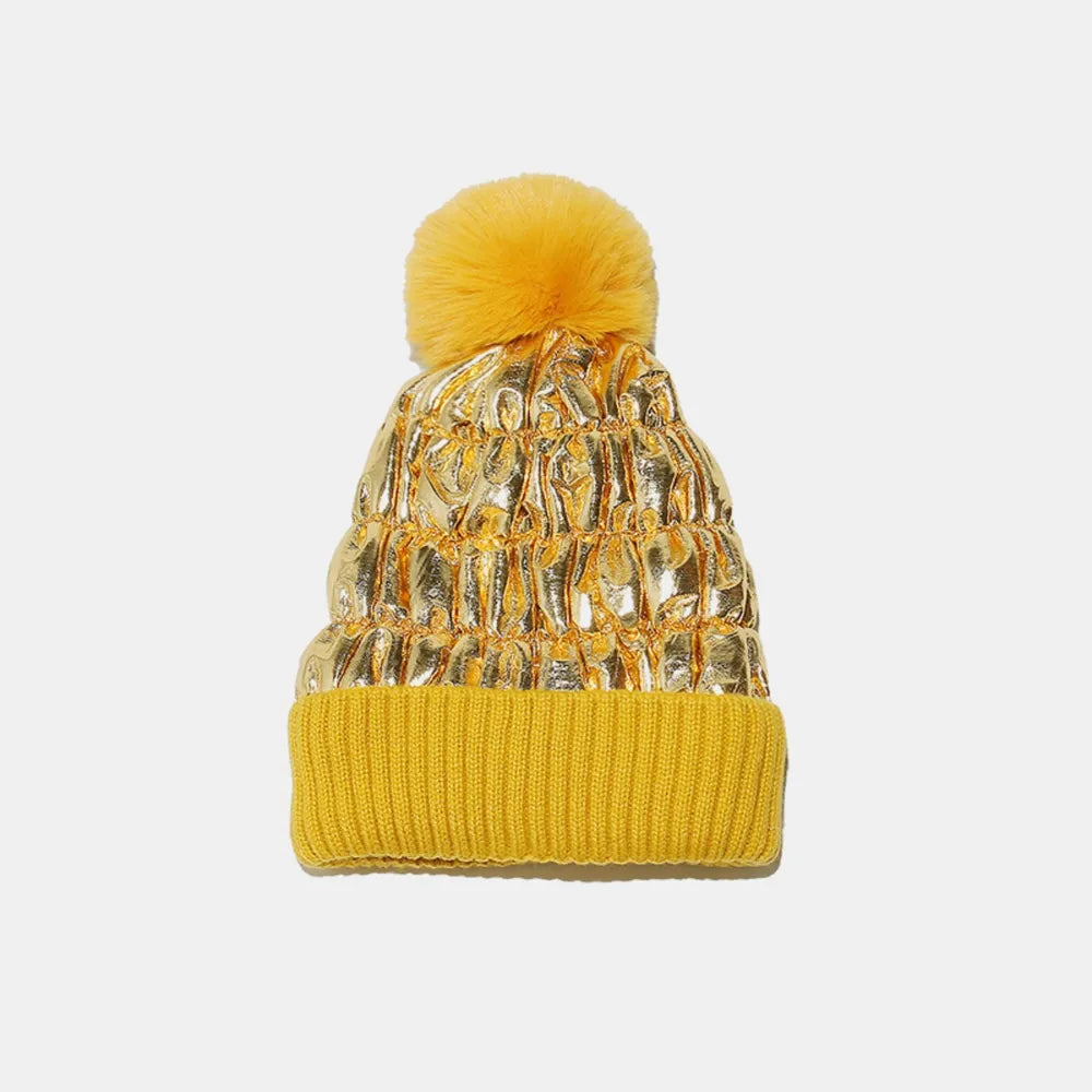 Metallic padded beanie with faux fur pom in gold and yellow ribbed cuff.