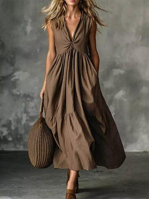 Brown linen maxi dress with knotted V-neck, sleeveless, tiered skirt, and pockets.