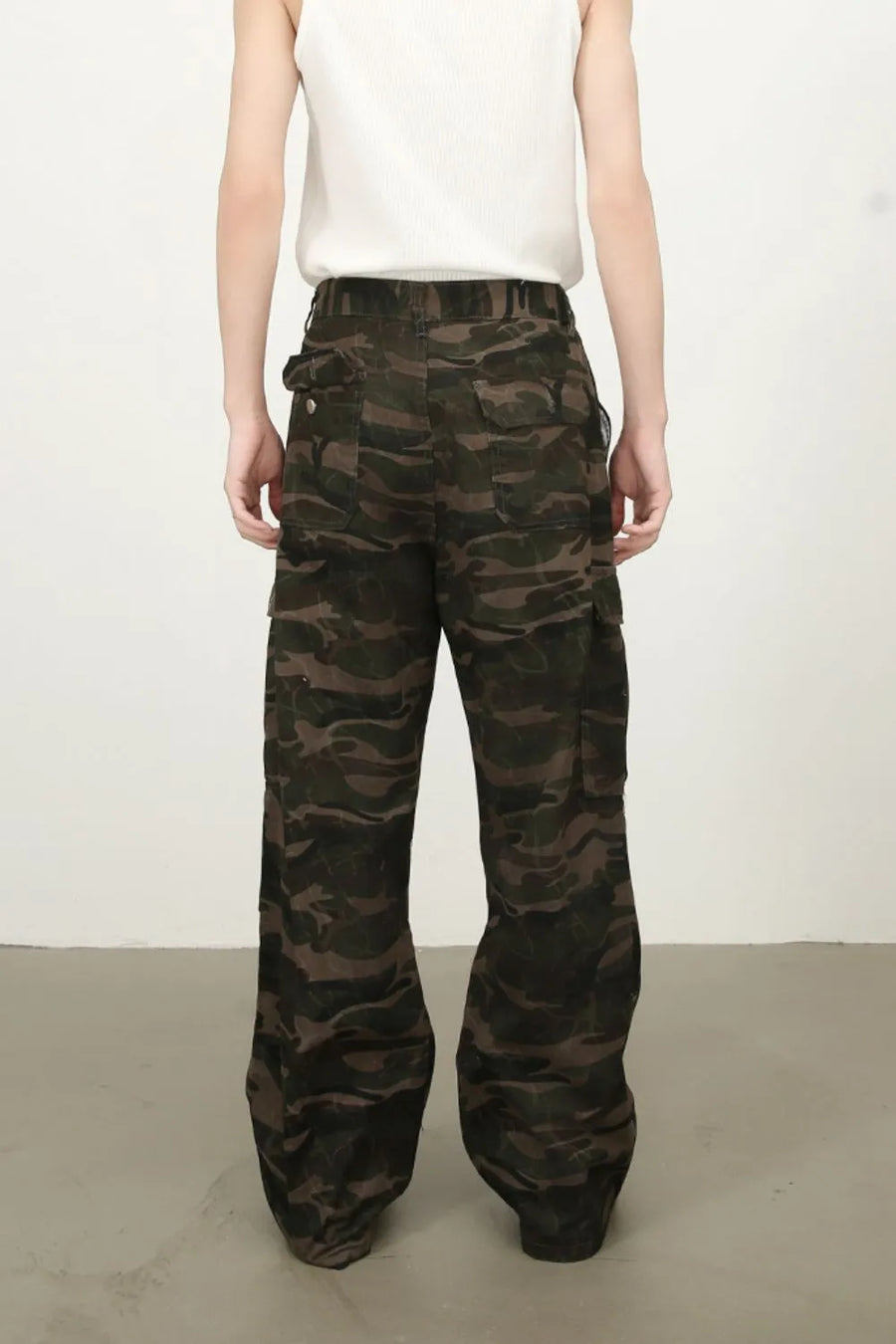 Wide-leg cargo pants in green camouflage with multiple pockets.
