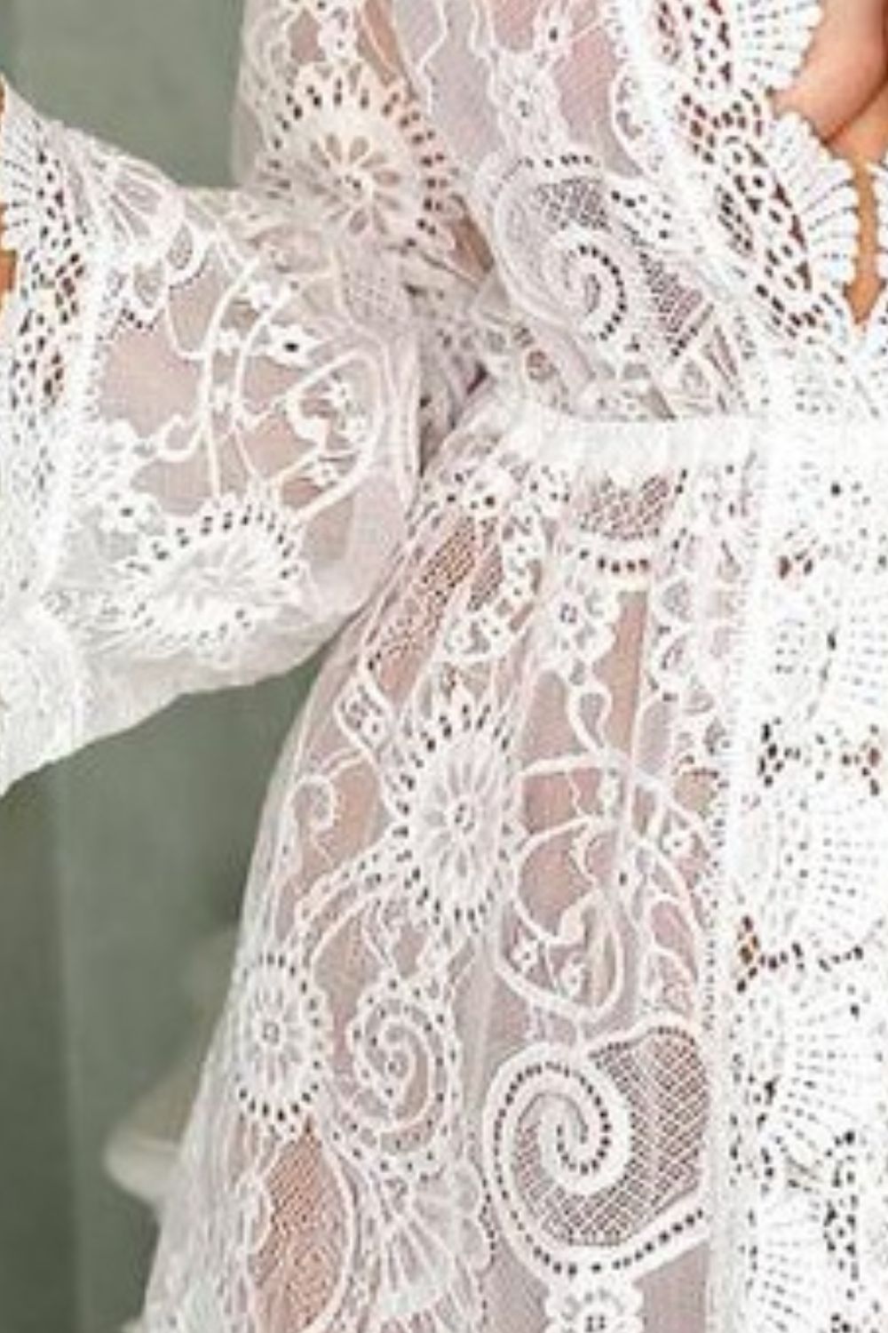 White lace bell sleeve cover-up with floral pattern and crochet details.