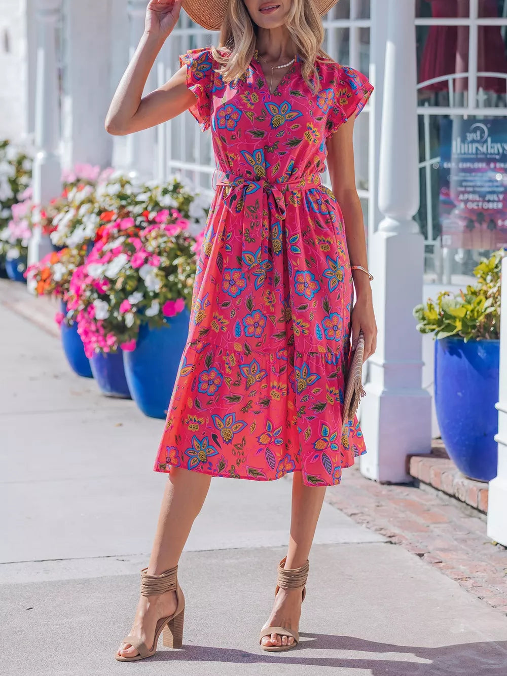 Floral midi dress with ruffled sleeves, belted waist, and tiered skirt in a cotton blend.
