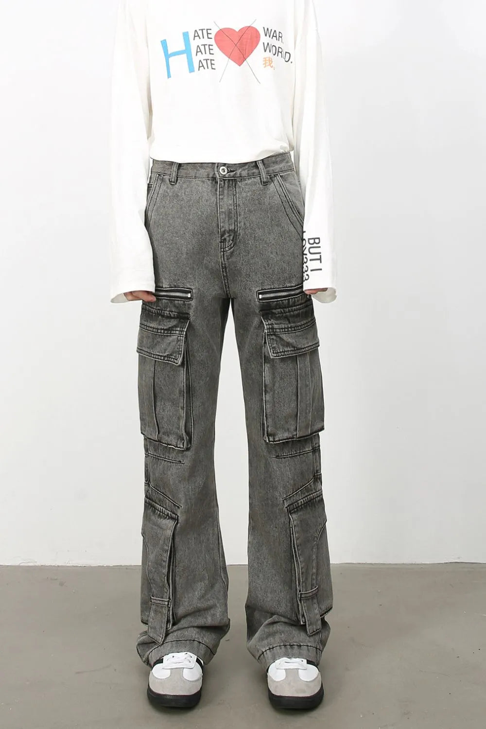 Acid wash flared cargo jeans in medium with multiple pockets and zipper details.