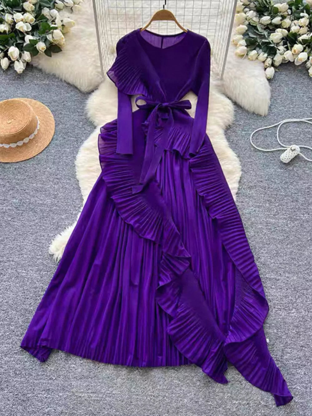 Purple midi dress with pleated skirt, ruffled asymmetrical hem, and tie waist.